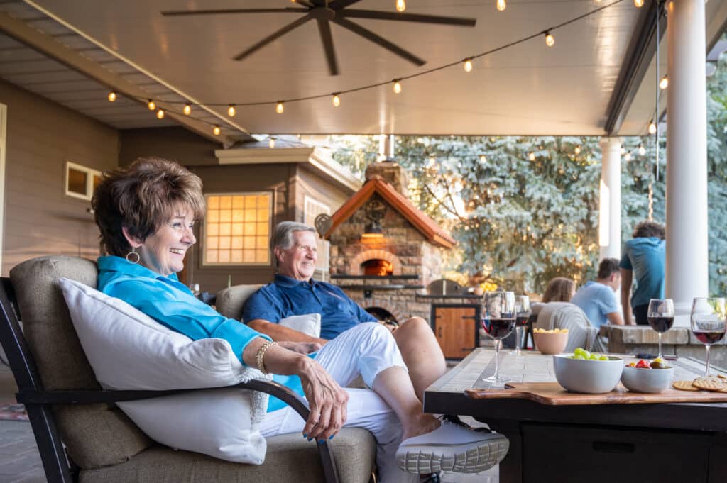 Family smiling while sitting around a fire on their patio in Nampa, Idaho.