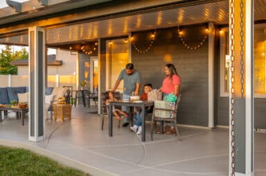 white and grey patio cover with scenery of a family enjoying their evening on the patio in Boise, Idaho.