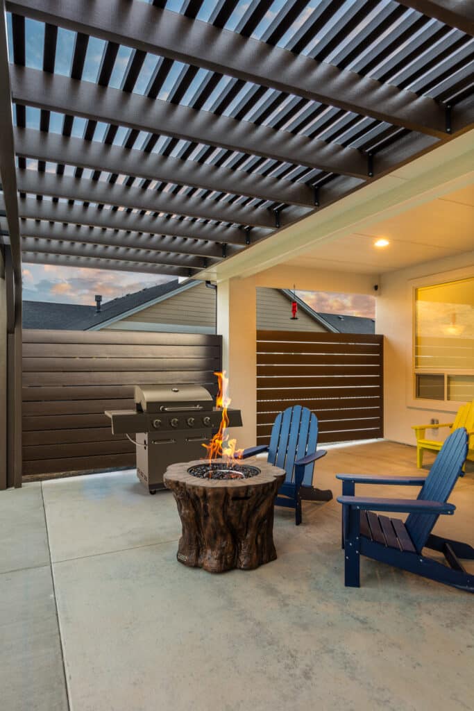 A brown pergola with a fire pit and blue patio chairs in Boise, Idaho.