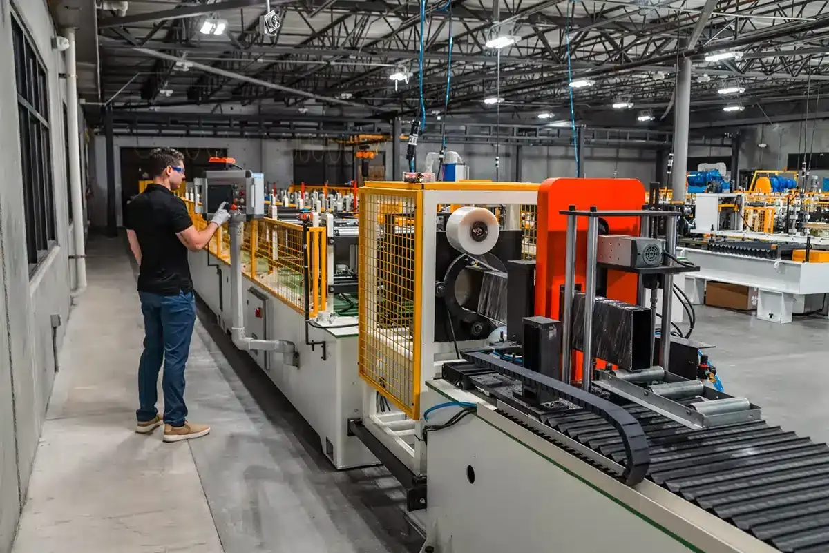 Technician operating aluminum fabrication machinery for custom patio covers at ShadeWorks manufacturing plant