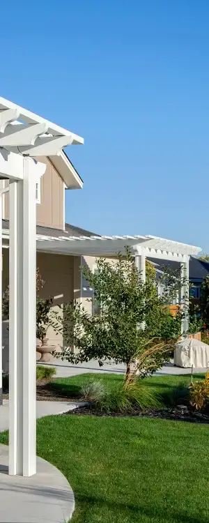 Modern white aluminum pergola providing filtered shade over residential patio