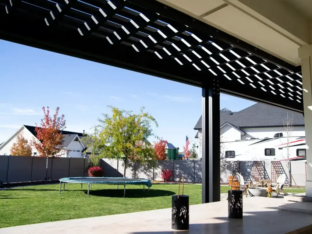 Sunlight filtering through pergola rafters creating shade pattern on patio