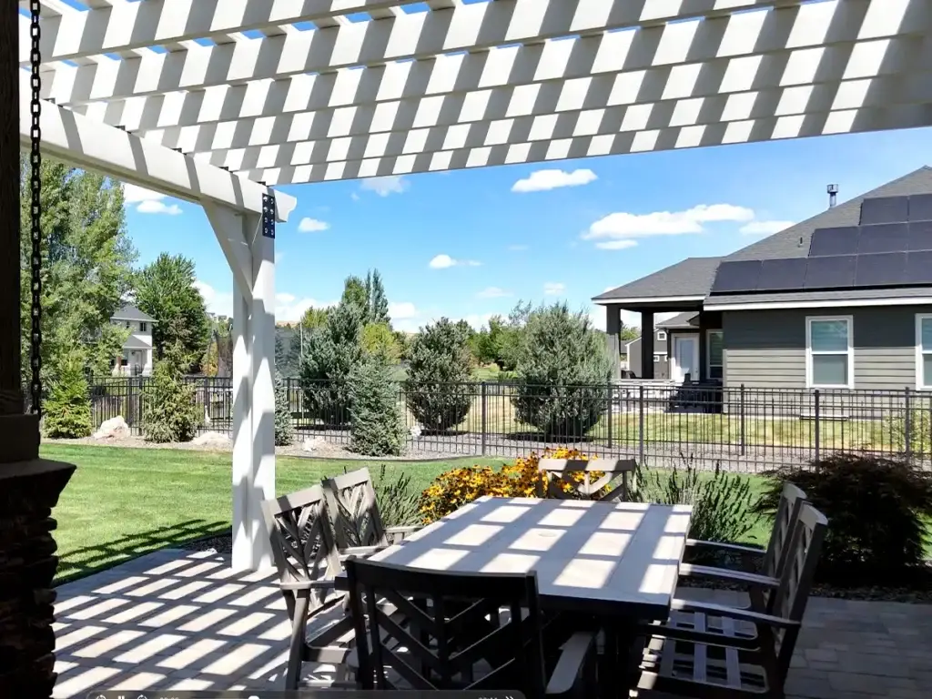 Pergola casting shade lines in backyard during Idaho summer heat