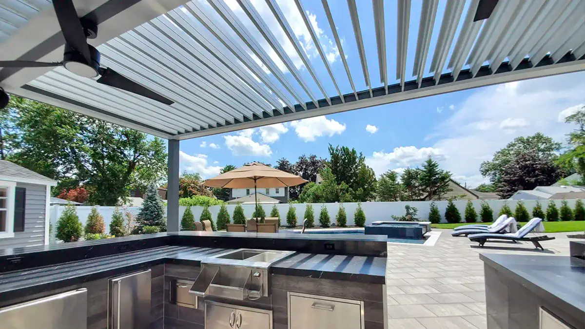 Louvered patio cover over backyard kitchen and bar area with shade