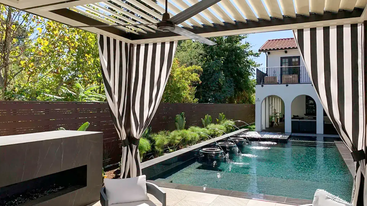 Louvered patio cover over pool with outdoor curtains for shade and privacy