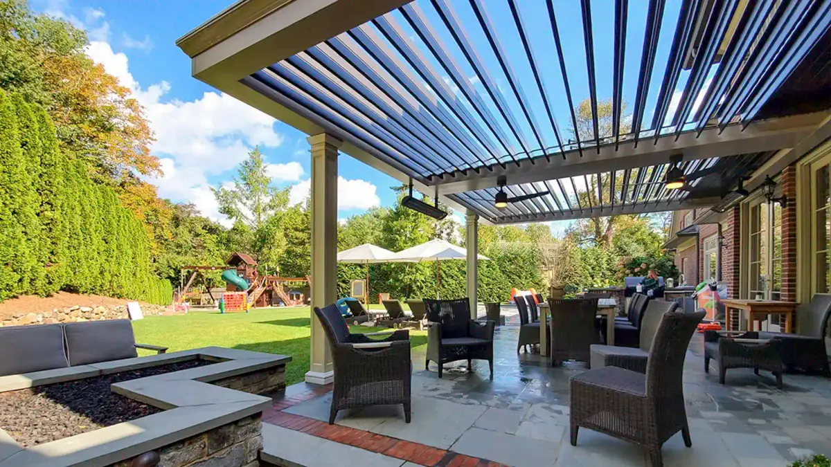 Louvered pergola covering outdoor living space with seating and patio area
