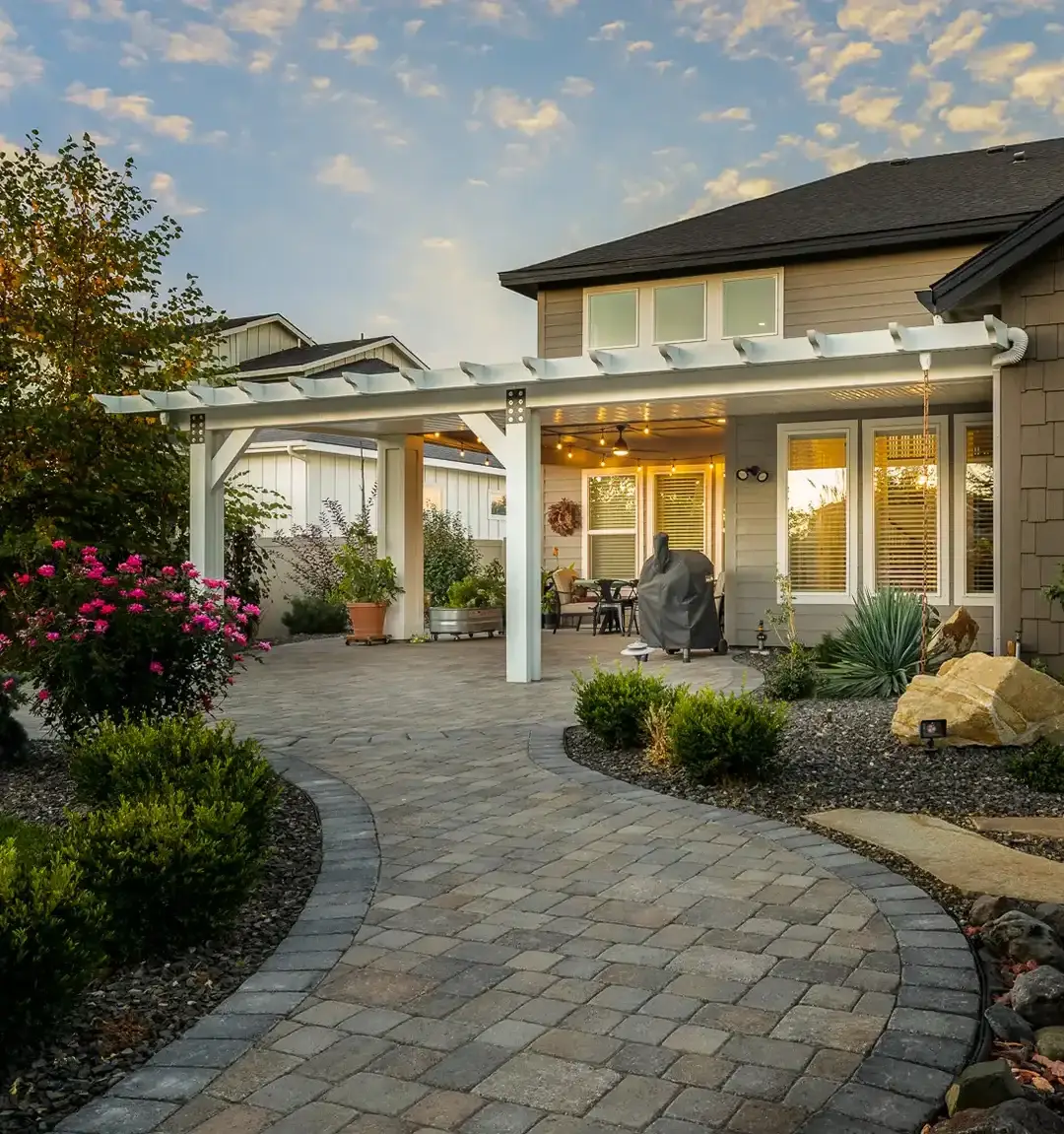 Custom white aluminum patio cover installed over backyard paver patio