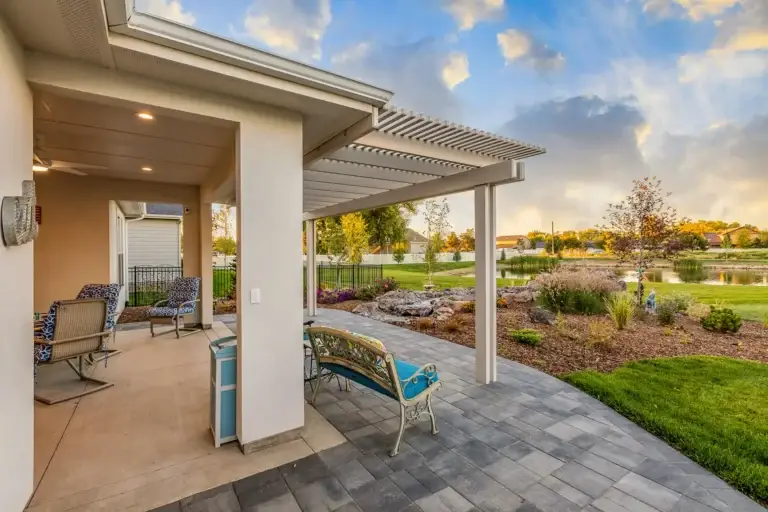 White aluminum pergola overlooking a waterfront backyard