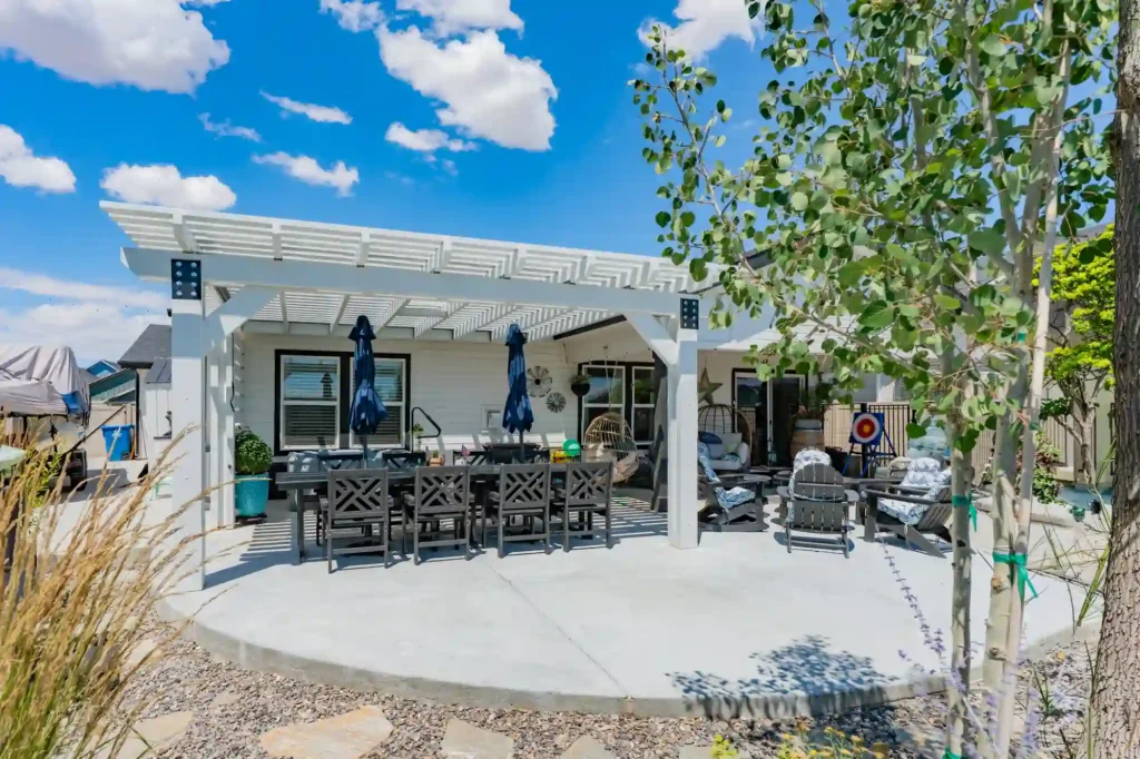 Custom white aluminum pergola creating a comfortable outdoor living and dining space in Meridian, Idaho.