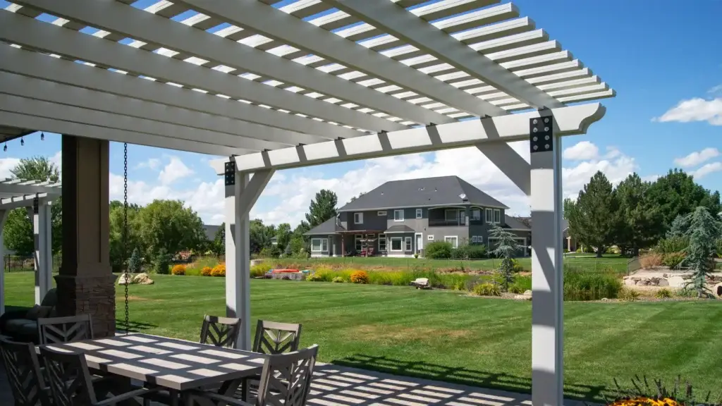 Custom white aluminum pergola covering an outdoor dining area in Meridian, Idaho.
