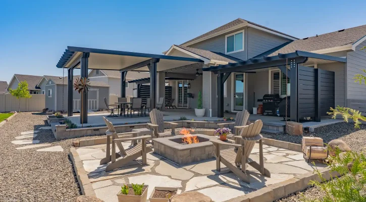 Backyard patio cover overlooking custom fire pit and outdoor gathering space in Boise