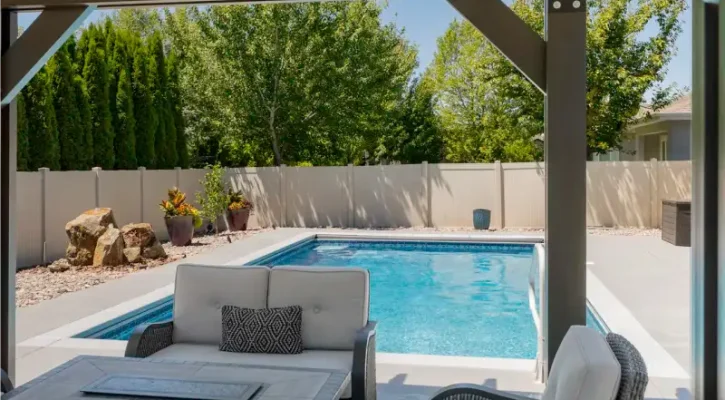 Covered Boise patio with outdoor seating area beside a pool, designed for shade, comfort, and protection from Idaho weather