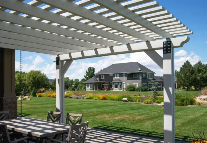 Custom white aluminum pergola covering an outdoor dining area in Meridian, Idaho.