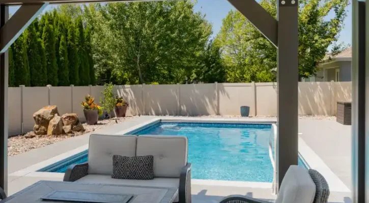 Freestanding patio cover providing shade beside a residential swimming pool in Boise